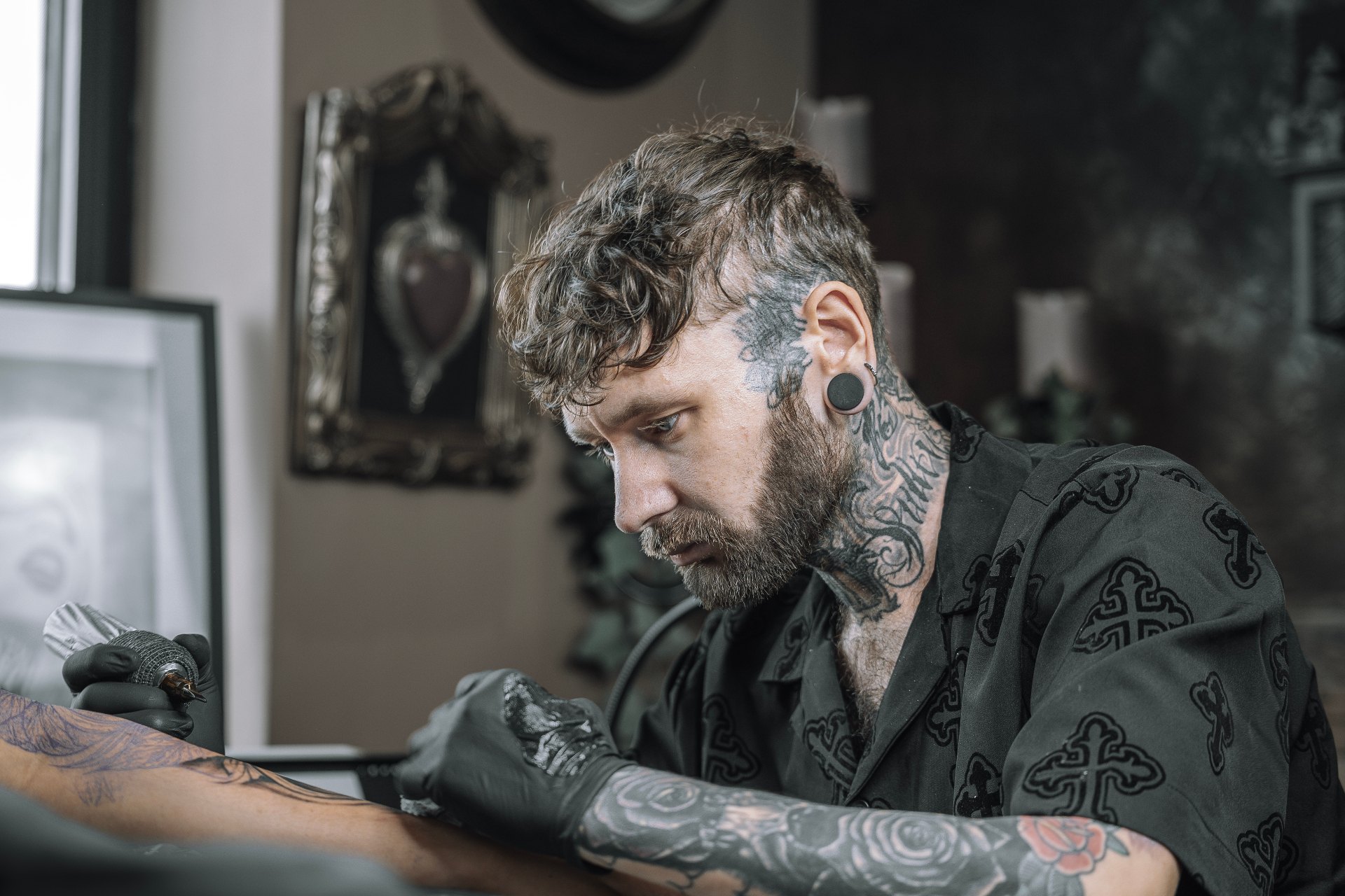 Jack Cooper tattooing a client's arm in the private Anarchy State studio